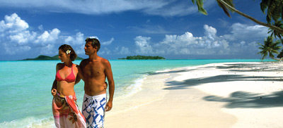 Couple walking on a paradisiac beach in The Islands Of Tahiti